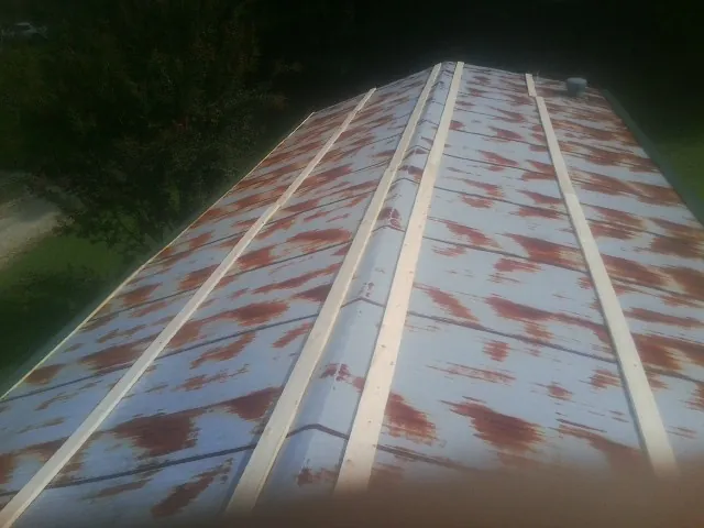 Rusted metal roof panels with new wood purlins before replacement — Storm Damage Roof Repair in Brigham City by Roofing Brothers
