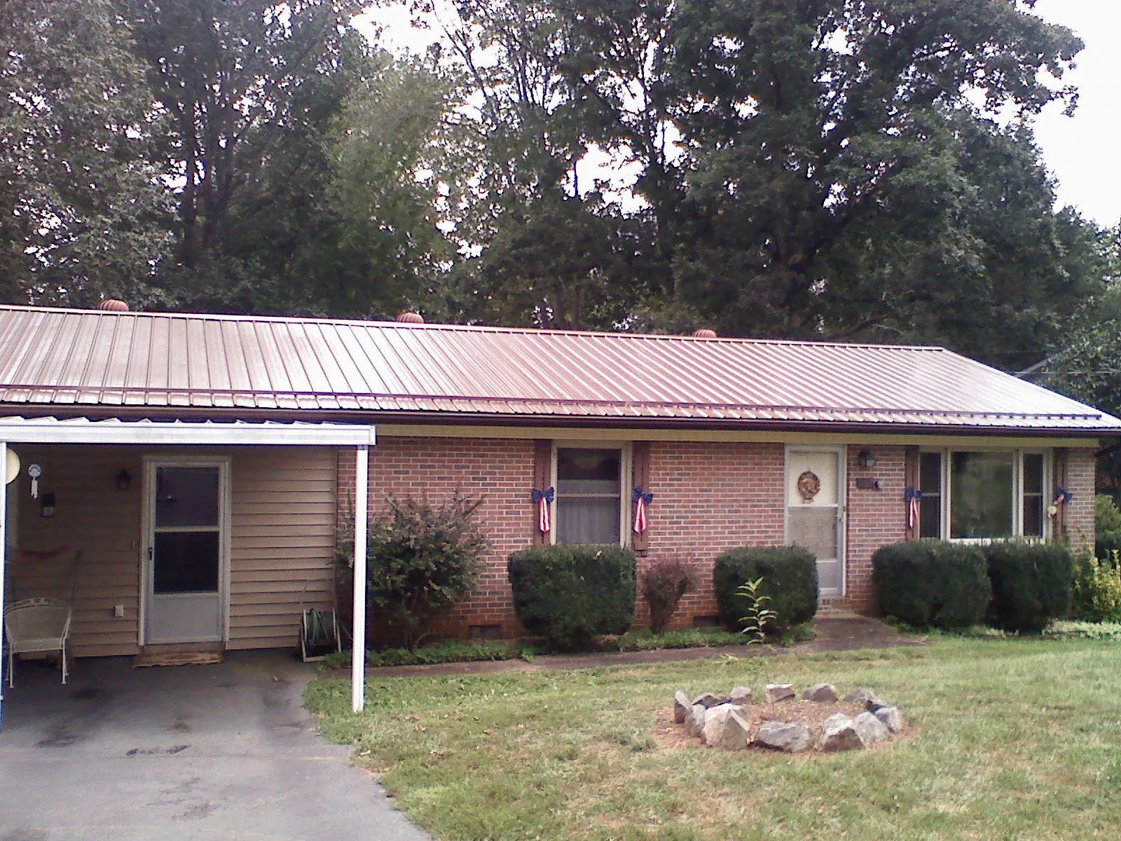 Bronze metal roof and carport on a brick ranch home — Roof Repair work by our crew in Brigham City