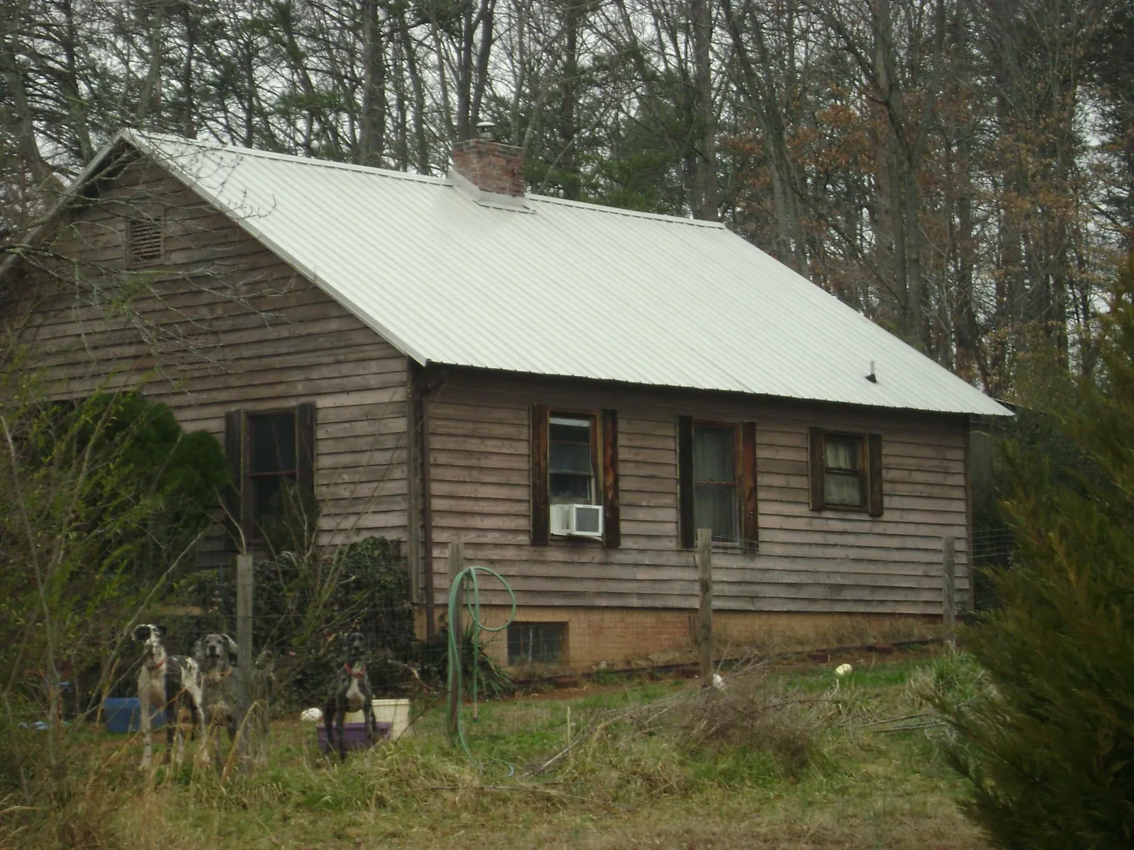 White metal roof on an old wood sided farmhouse, from a Metal Roof Installation job in Brigham City